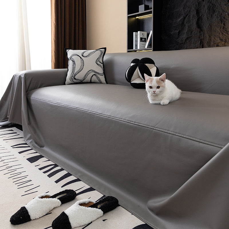Jeté de canapé en simili cuir beige sur un canapé gris