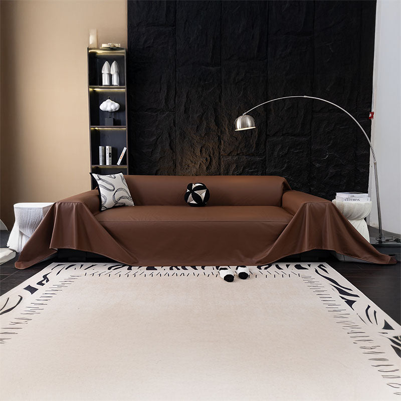 Jeté de canapé en simili cuir beige sur un canapé gris