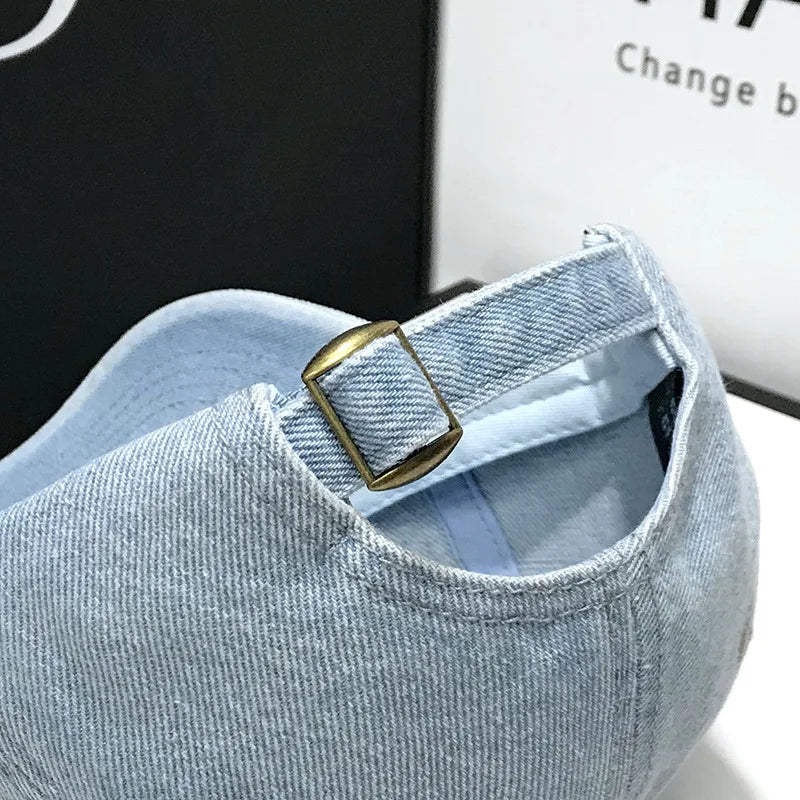 Détail de la broderie sportive sur casquette en denim