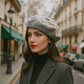 Jeune femme portant un béret élégant en coton, regard pensif