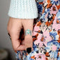 Gros plan sur les cabochons turquoise de la bague argentée