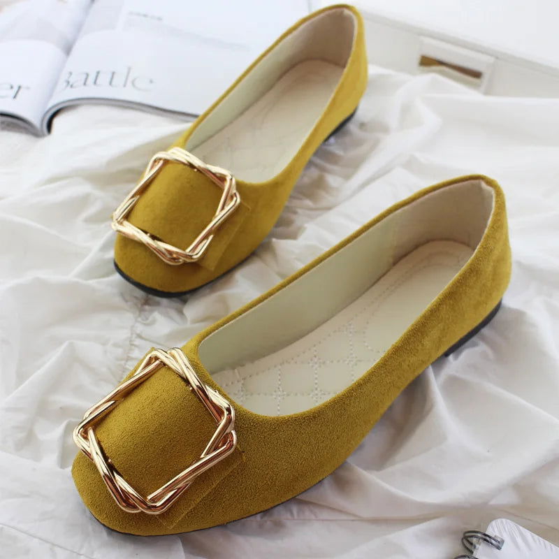 Ballerines avec boucle dorée sur fond blanc, vue de côté