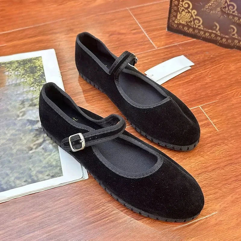 Ballerines noires posées sur une surface claire, bride en évidence