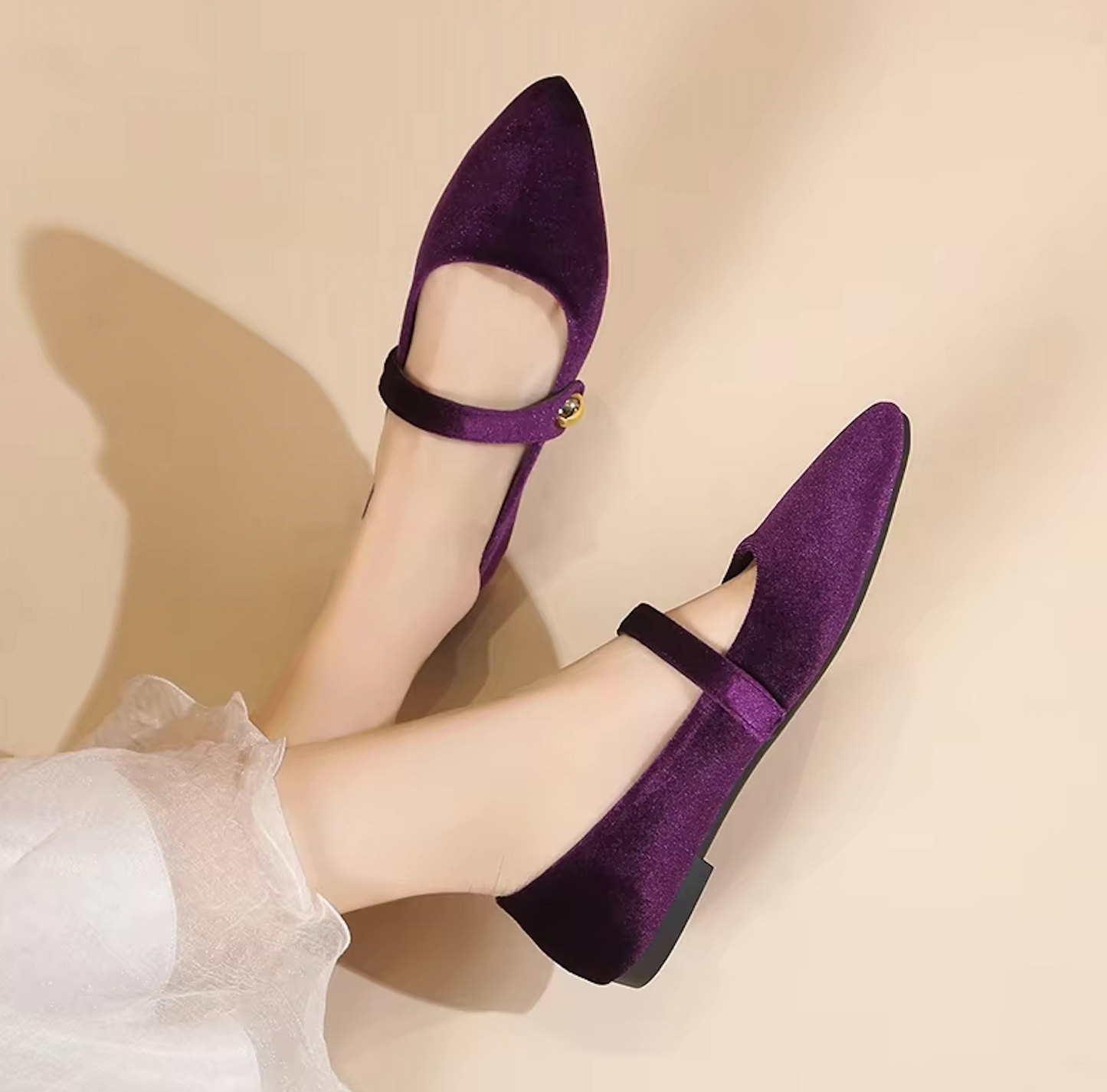 Ballerines en velours posées sur une surface en bois
