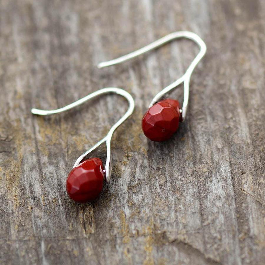 Boucles d'oreilles en jaspe rouge facetté sur fond blanc