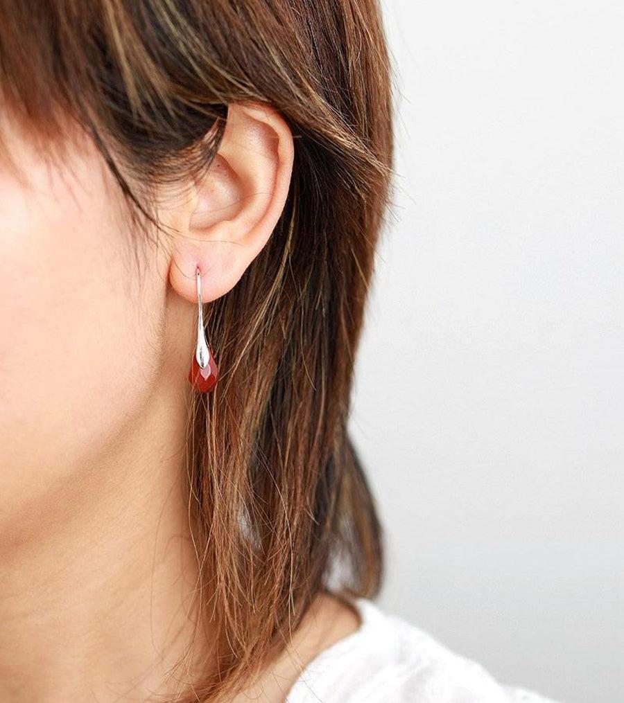 Vue latérale des boucles d'oreilles en jaspe rouge et laiton argenté