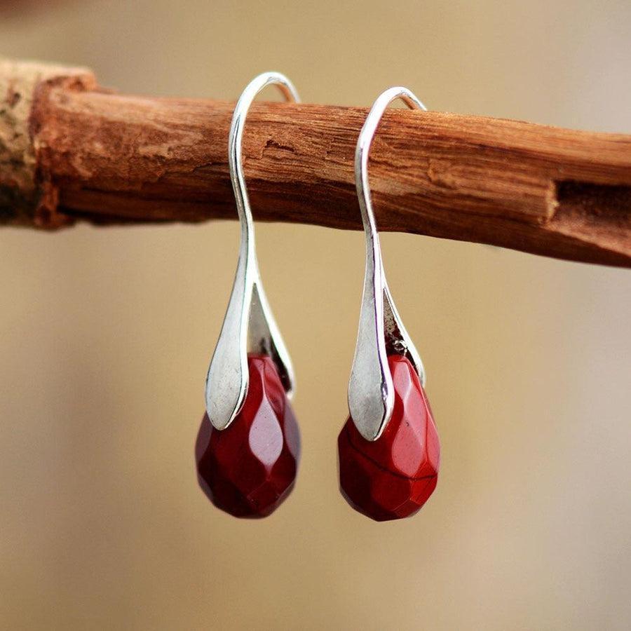 Boucles d'oreilles pendantes avec pierres rouges et support argenté