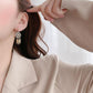 Détail d'attrape-rêve cerclé de strass sur boucles d'oreilles
