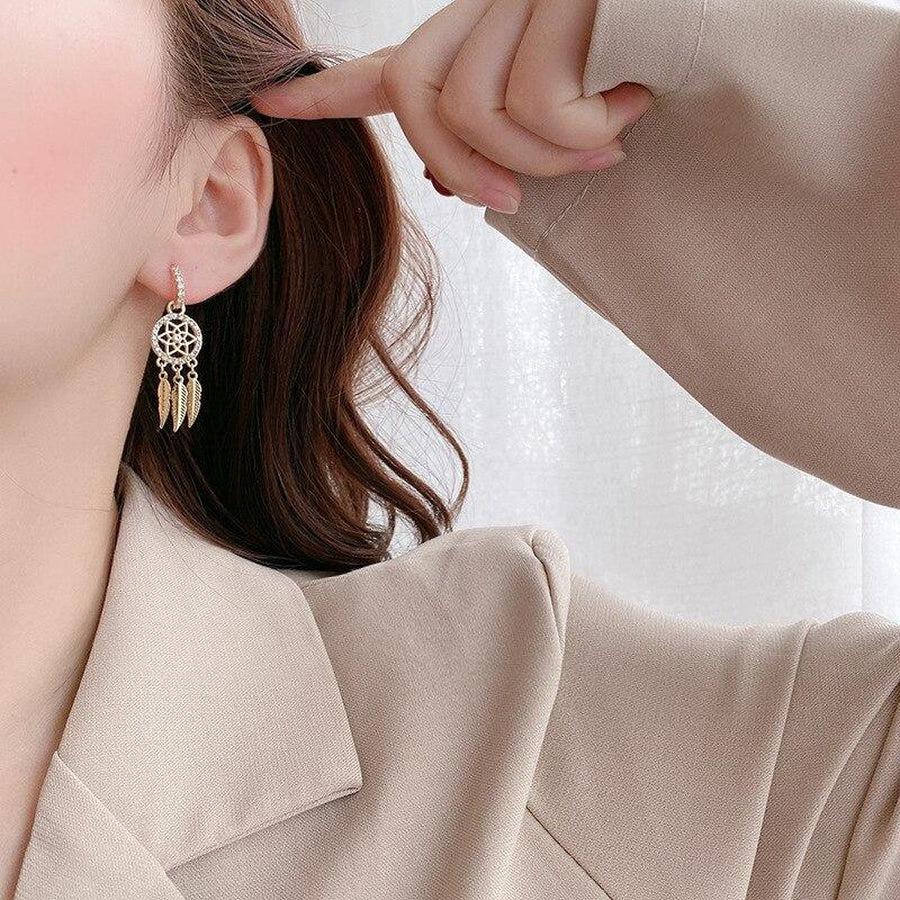 Détail d'attrape-rêve cerclé de strass sur boucles d'oreilles