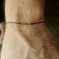 Bracelet en corde fine avec détail du cylindre en bronze