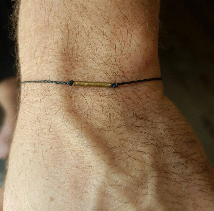 Bracelet en corde fine avec détail du cylindre en bronze
