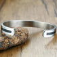 Détail du symbole OM sur le bracelet en acier