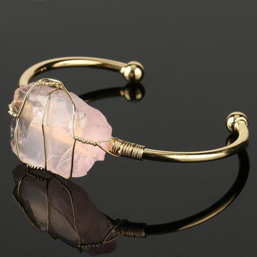 Bracelet doré avec pierre centrale améthyste en gros plan