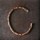 Bracelet en cuivre martelé sur fond blanc, vue de côté