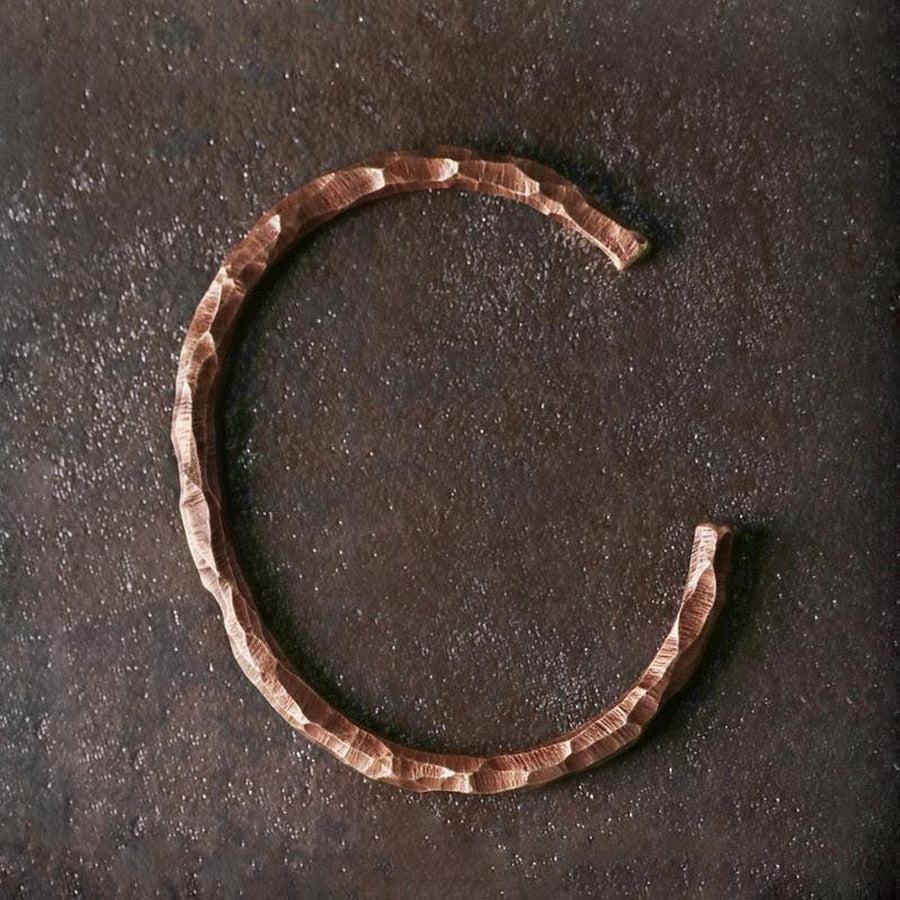 Bracelet en cuivre martelé sur fond blanc, vue de côté