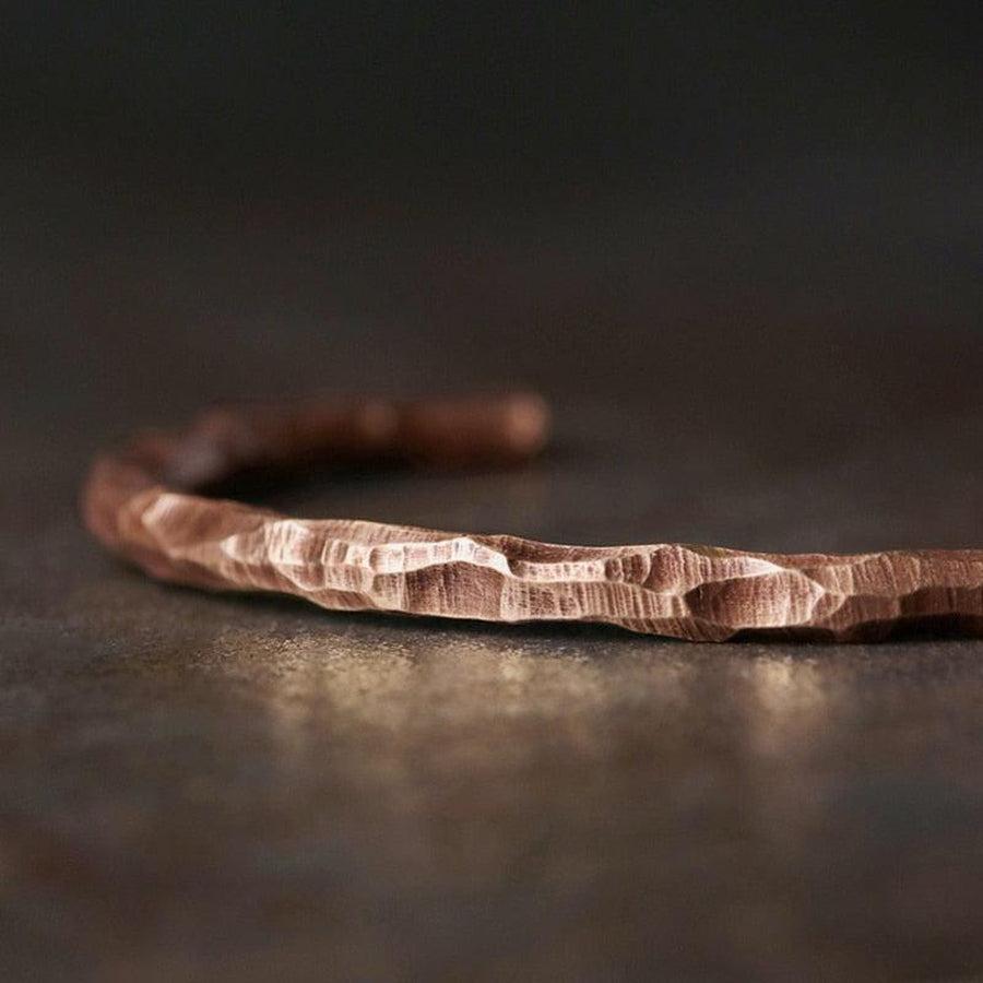 Gros plan sur le motif martelé du bracelet en cuivre
