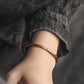 Bracelet en cuivre ajustable, posé sur une surface en bois