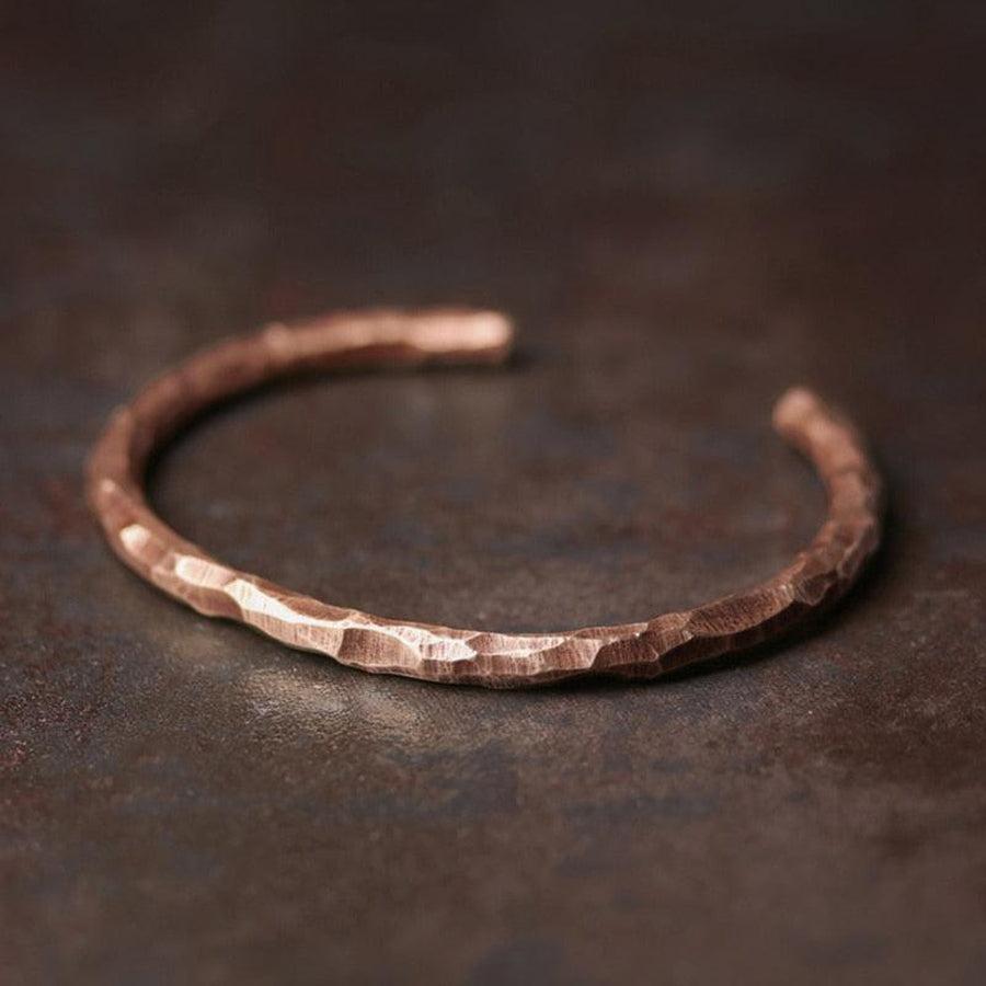 Bracelet en cuivre martelé, élégant et simple, sur fond neutre