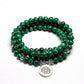 Gros plan sur les perles vert profond du bracelet