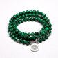 Bracelet mala en malachite posé sur une surface en bois