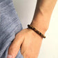 Bracelet artisanal avec perle cylindrique Om sur coton coloré