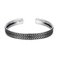 Gros plan sur un bracelet jonc argenté, texture lisse