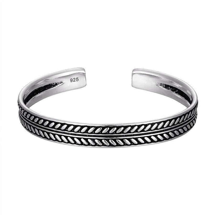 Gros plan sur un bracelet jonc argenté, texture lisse
