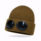 Bonnet avec lunettes posé sur une surface en bois