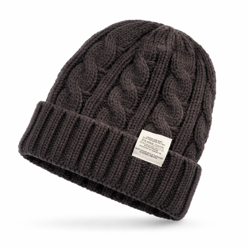 Bonnet en maille torsadée, posé sur un fond clair