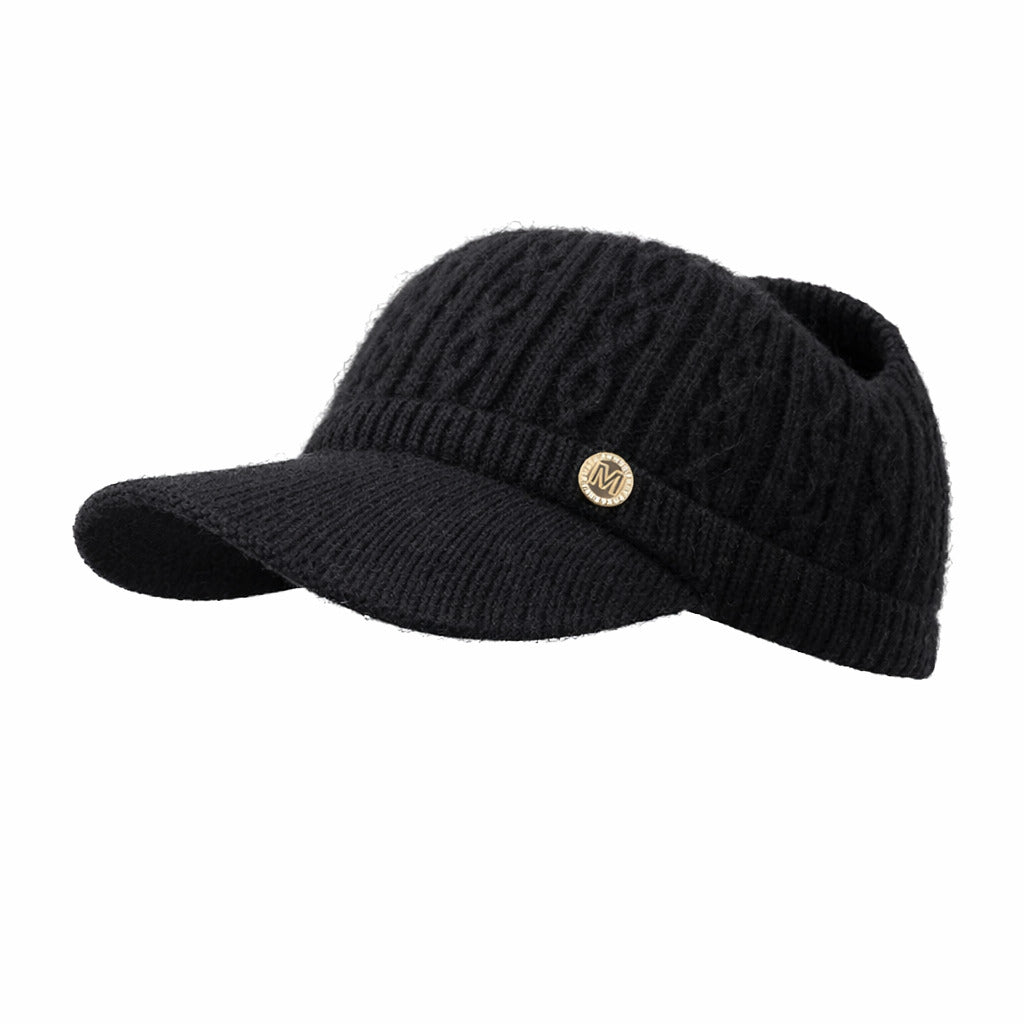 Bonnet en maille torsadée posé sur une surface en bois
