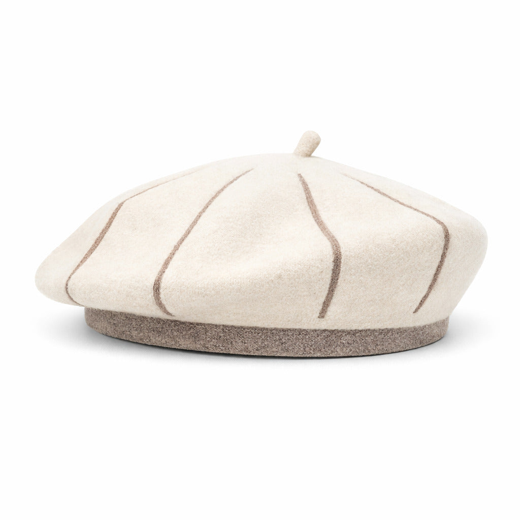 Béret en laine bleu marine posé sur une table en bois