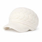 Femme portant le bonnet, souriant en extérieur enneigé
