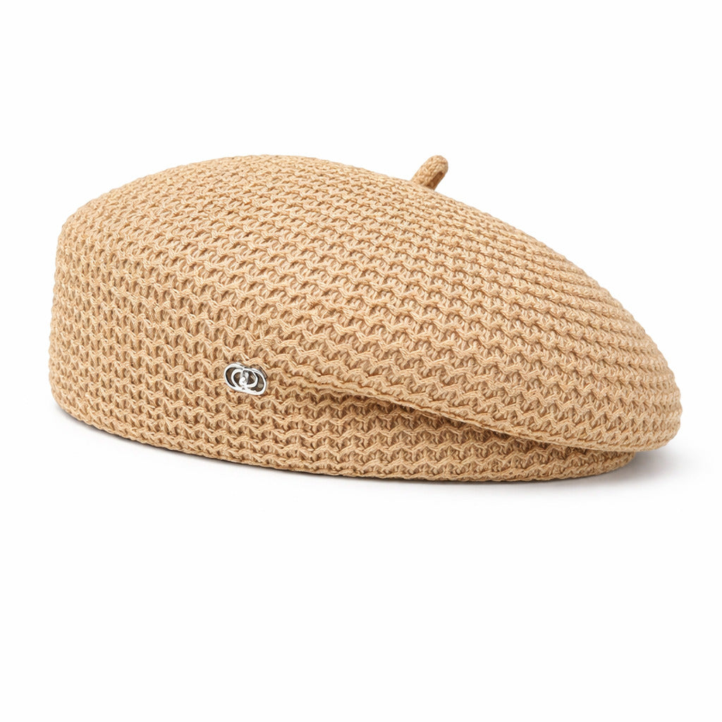 Béret féminin posé sur une surface en bois clair