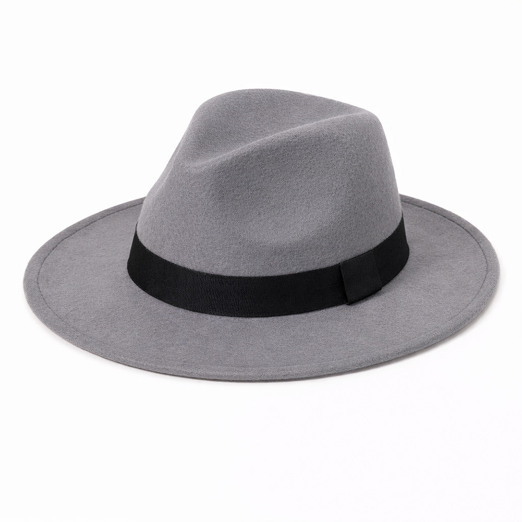 Chapeau Fedora gris sur un fond de mur en briques