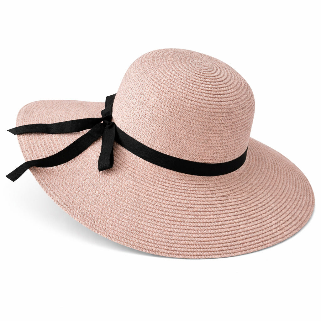 Chapeau de paille sur une table en terrasse, vue sur jardin
