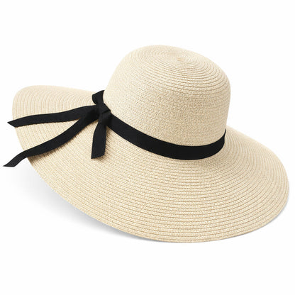 Chapeau de paille sur une table en bois, entouré de fleurs