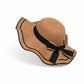Femme souriante portant un chapeau de paille en extérieur