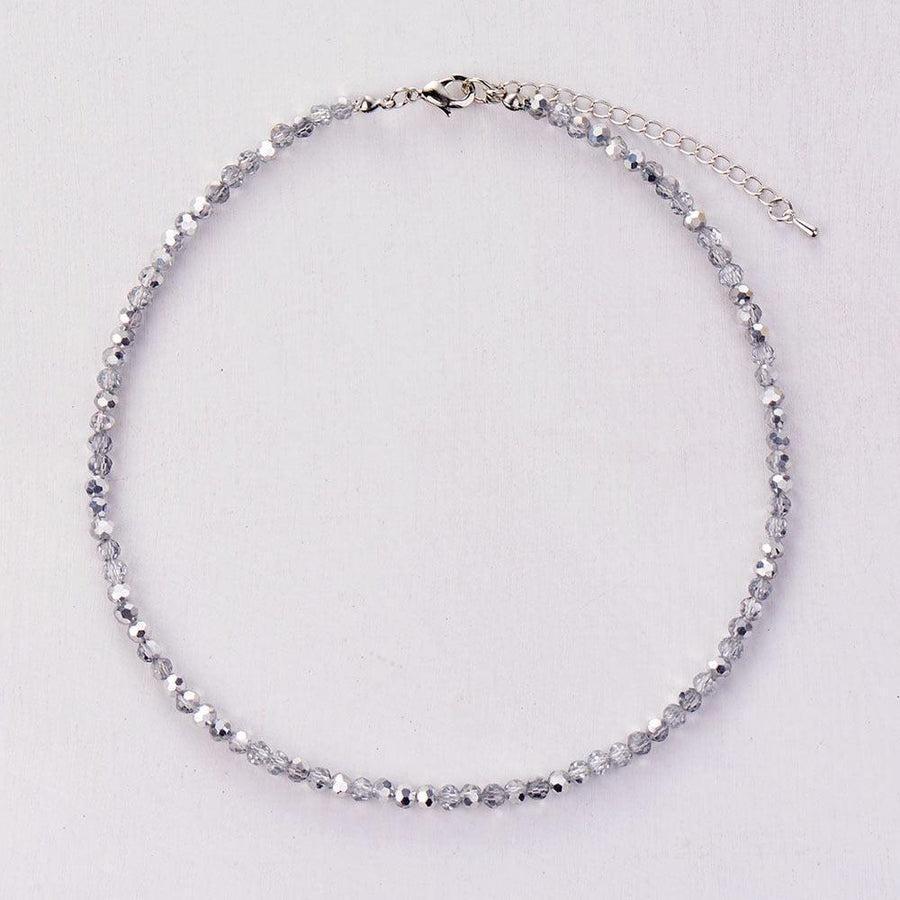 Gros plan sur le fermoir mousqueton du collier en cristal