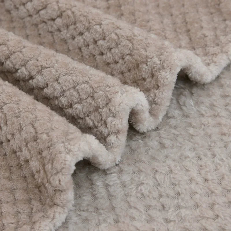 Couverture cocooning en velours luxueux repliée sur un lit