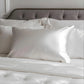 Taie d'oreiller en soie blanche sur un lit