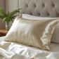 Taie d'oreiller en soie beige sur lit blanc