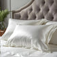 Taie d'oreiller en soie blanche sur un lit