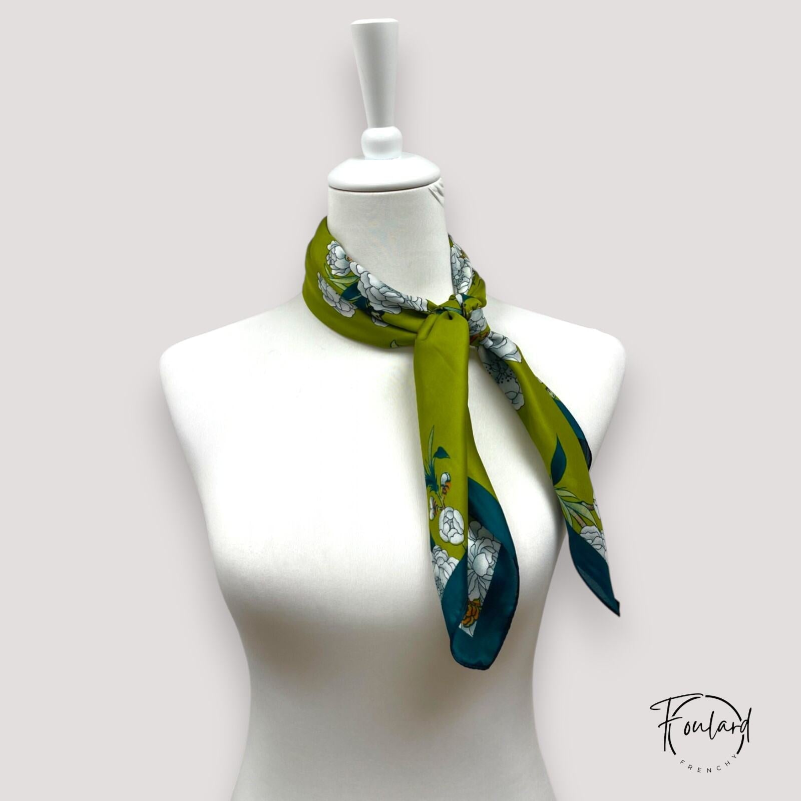 Foulard carré noué, montrant le motif floral et les grues