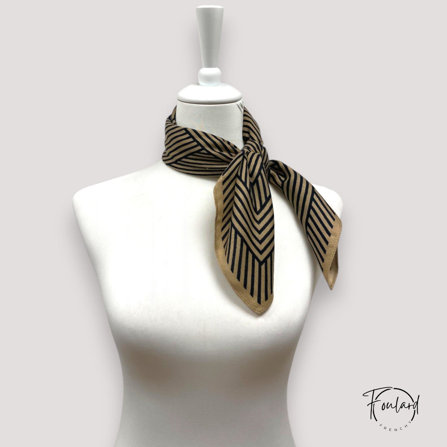 Foulard noué, texture douce et motifs noirs sur beige