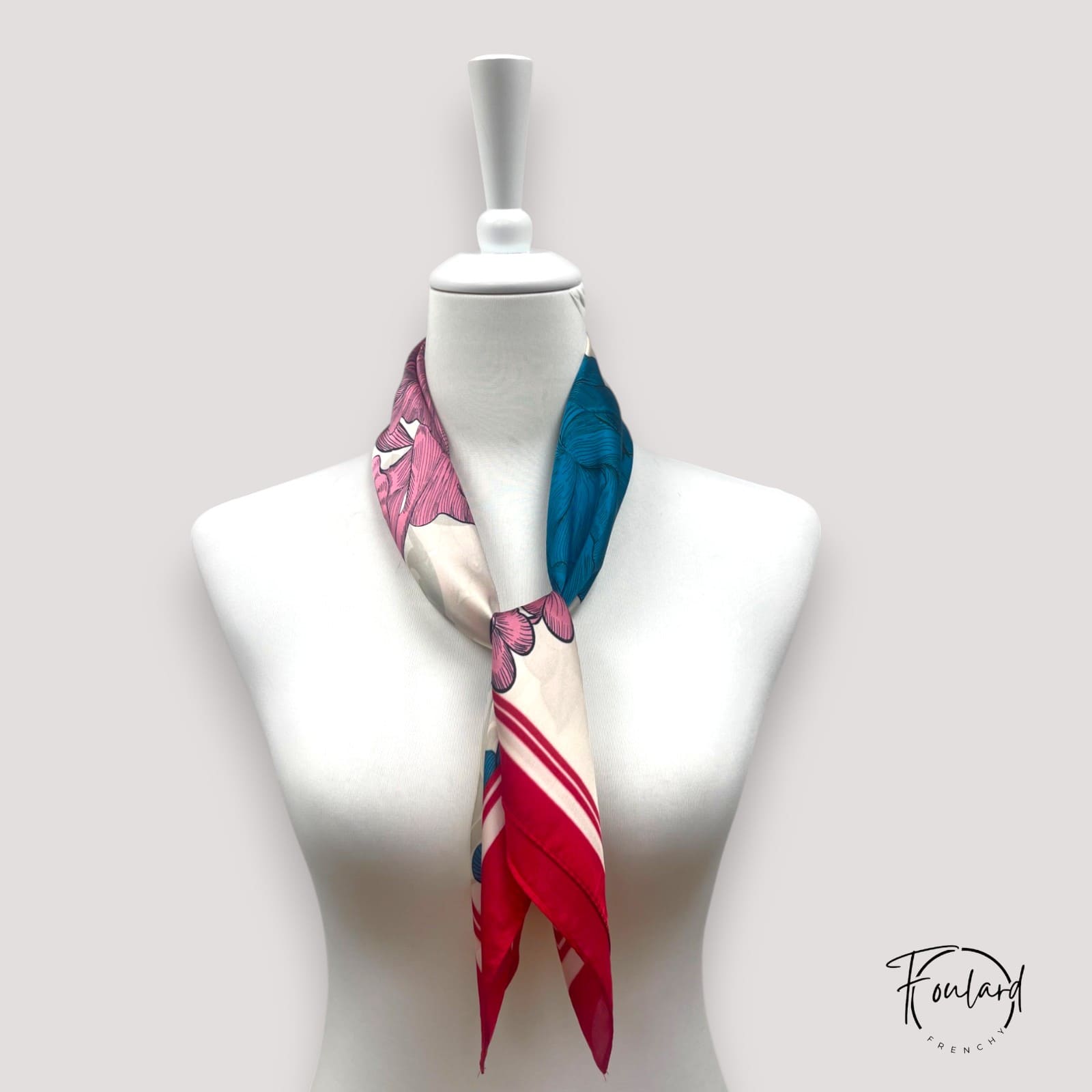 Détail des fleurs illustrées en rose, bleu et crème sur le tissu