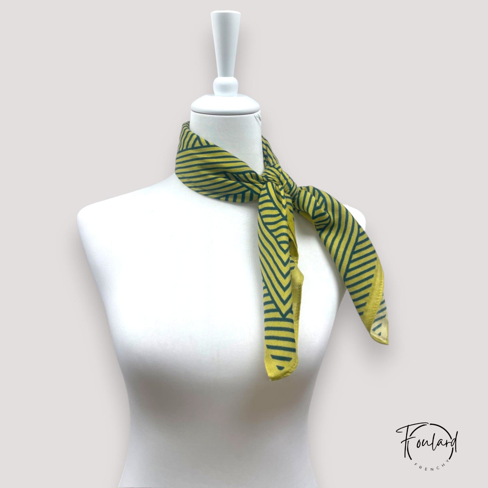 Gros plan sur le motif géométrique vert et jaune du foulard