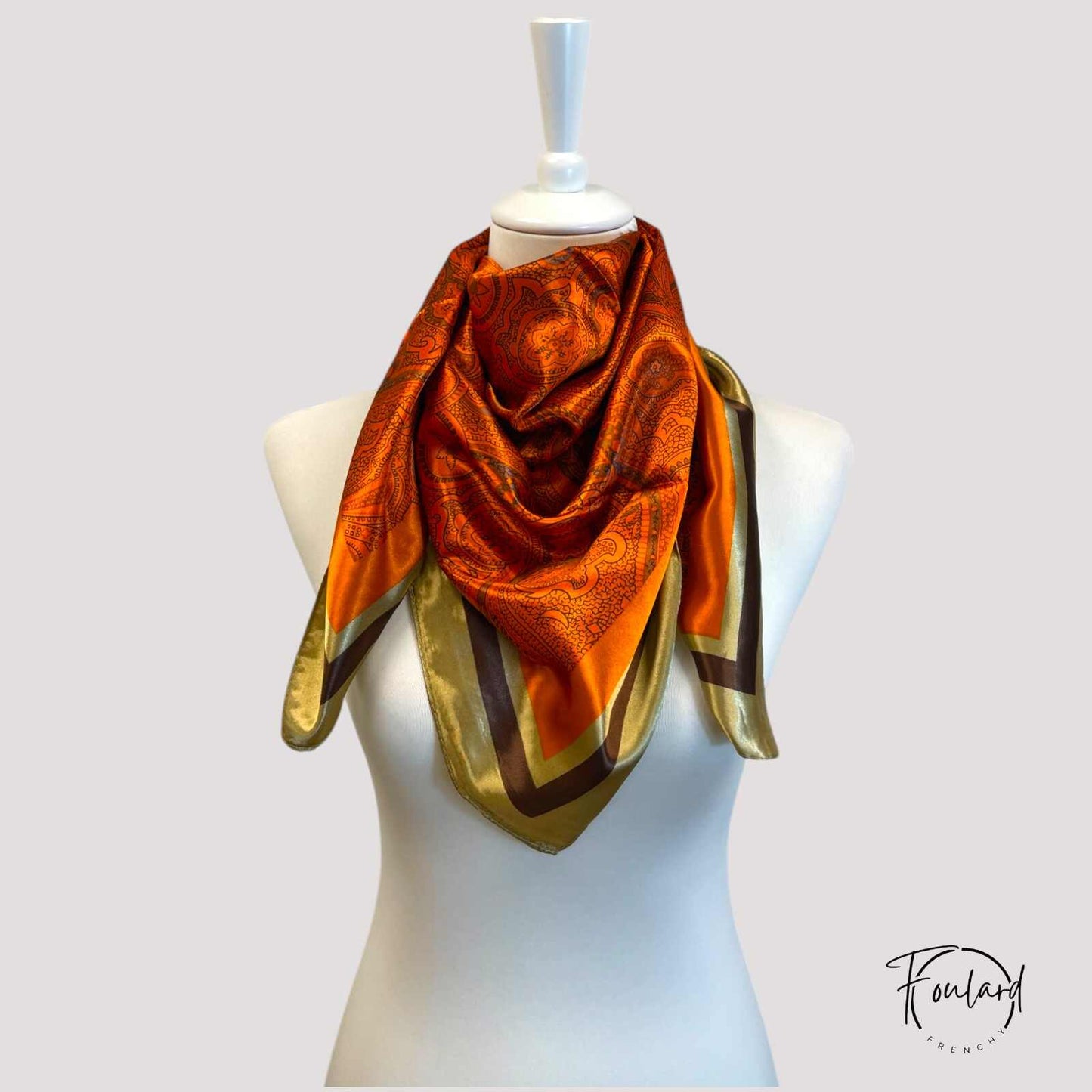 Zoom sur le motif raffiné du foulard rouge orangé