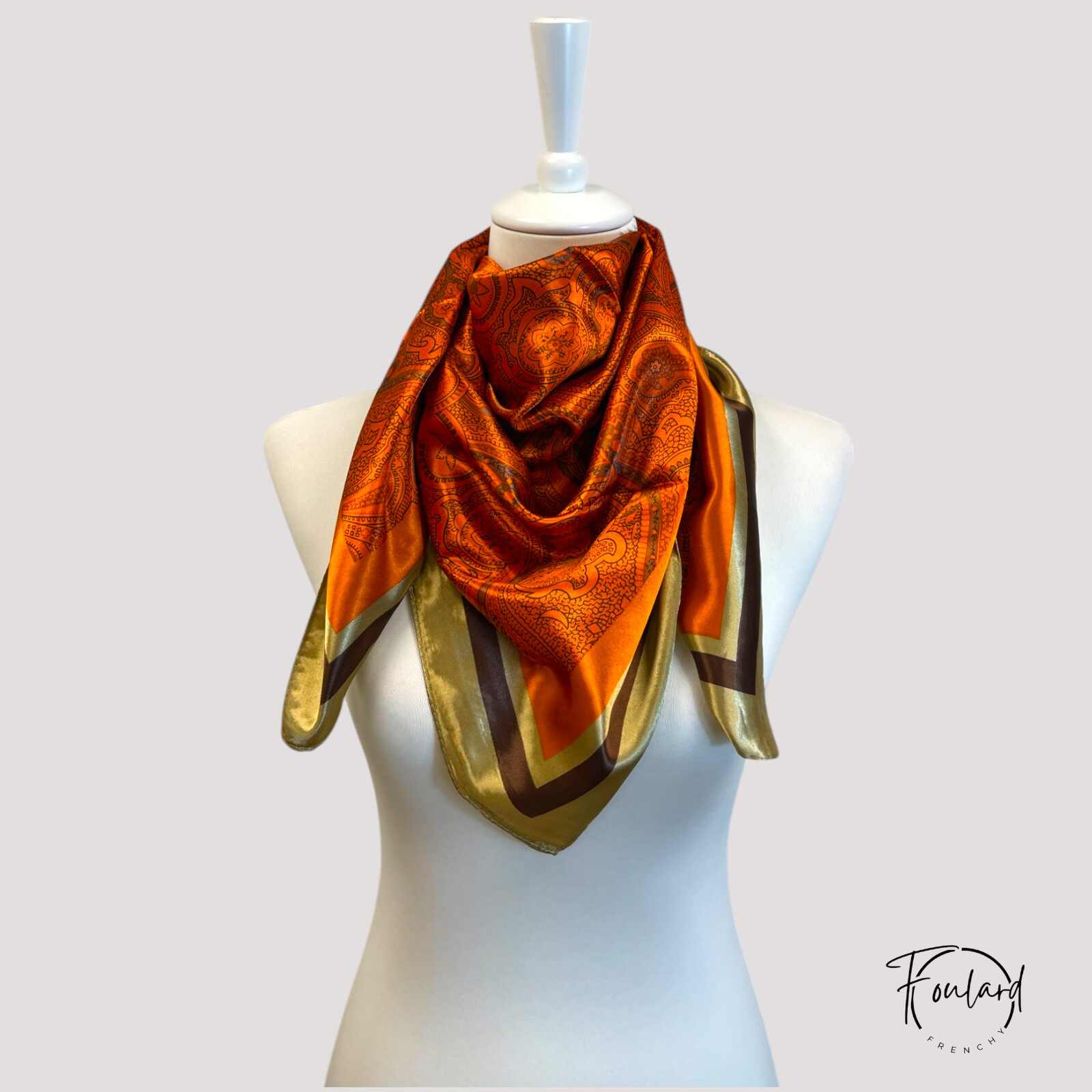 Zoom sur le motif raffiné du foulard rouge orangé