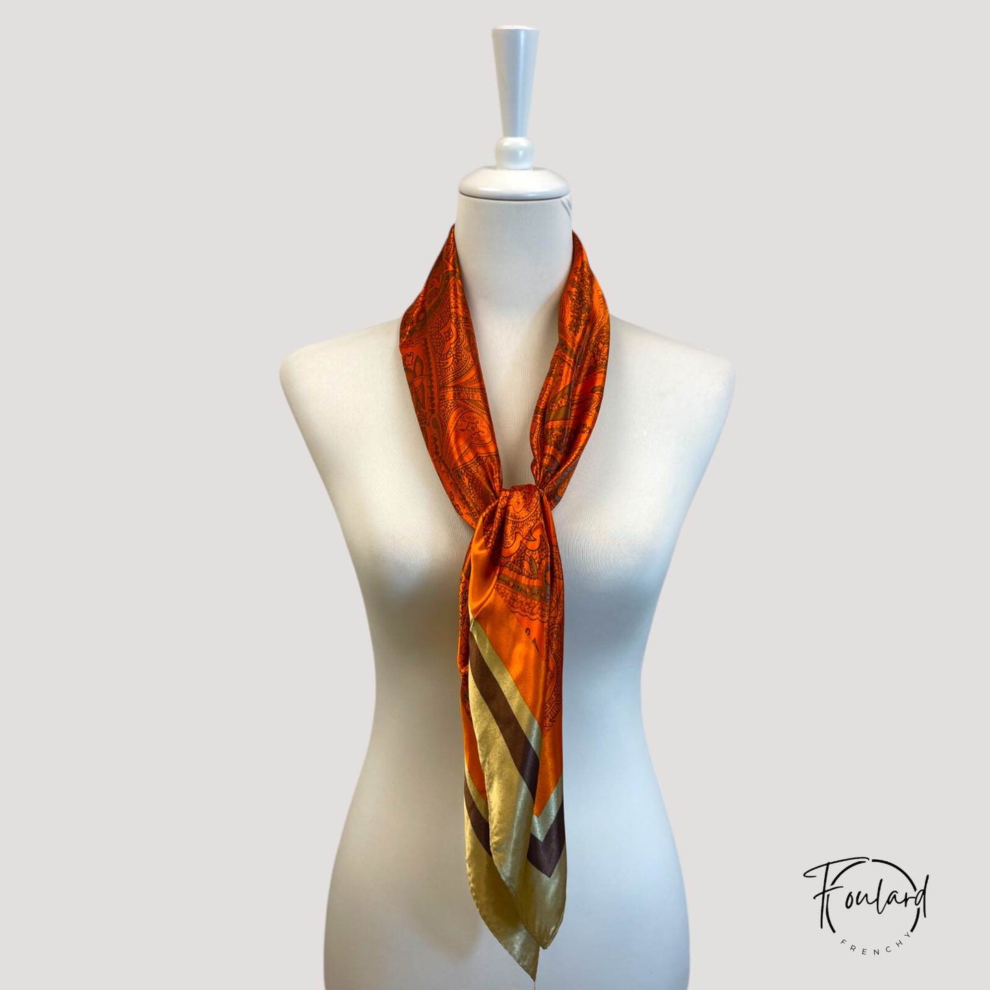 Foulard carré noué, montrant sa texture lisse et chic