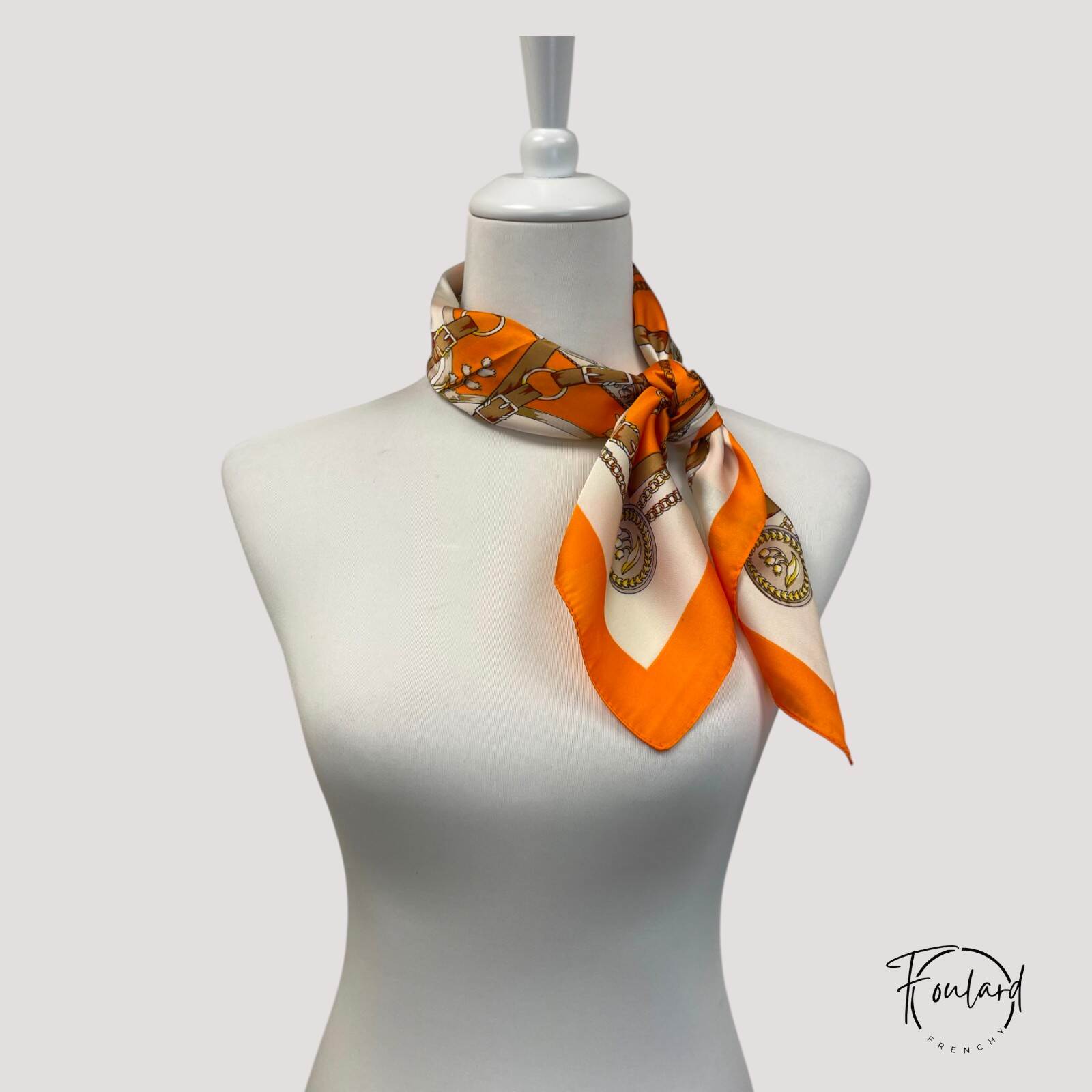 Foulard orange enroulé, mettant en avant sa souplesse